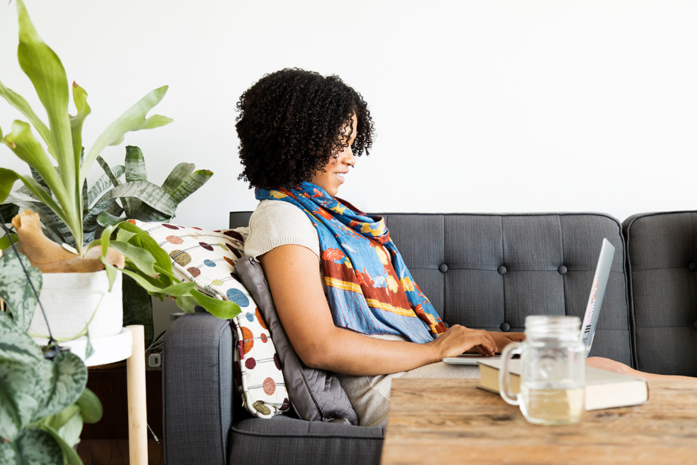 woman working on computer on the couch